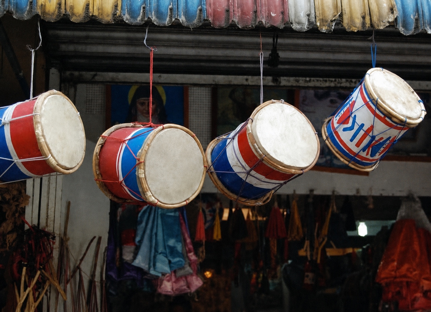 Red, white, and blue drums hanging outside a market